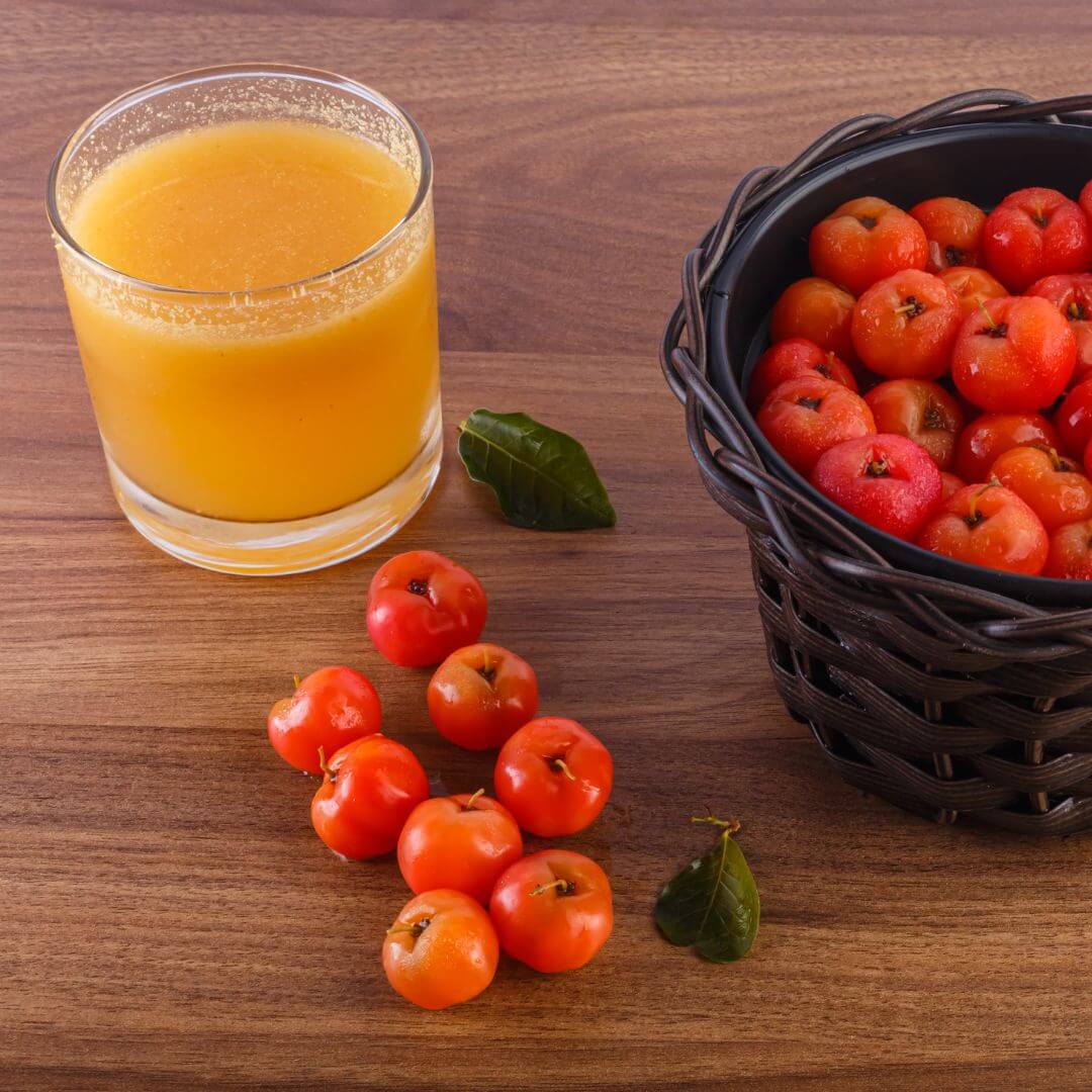 acerola cherry juice in a glass and cherries