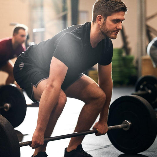 man deadlifting weights in gym