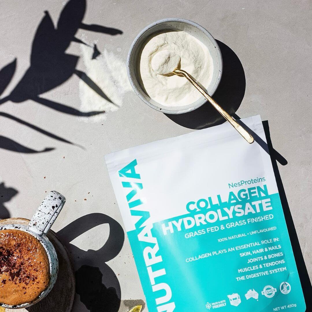 pack of collagen protein powder on bench with a bowl containing collagen powder next to a cup of cacao