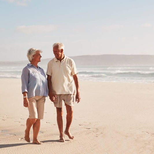 older couple walking on beach