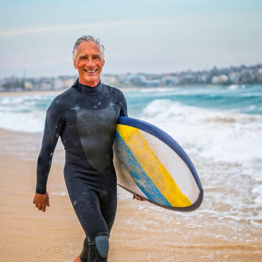 man at beach with surfboard