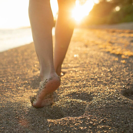 person walking along the beach at sunrise