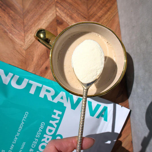 collagen powder on a spoon about to be stirred into a drink with Nutraviva collagen powder pack on bench