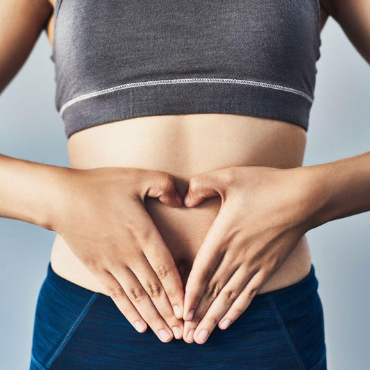 lady making a heart sign with hands in front of stomach