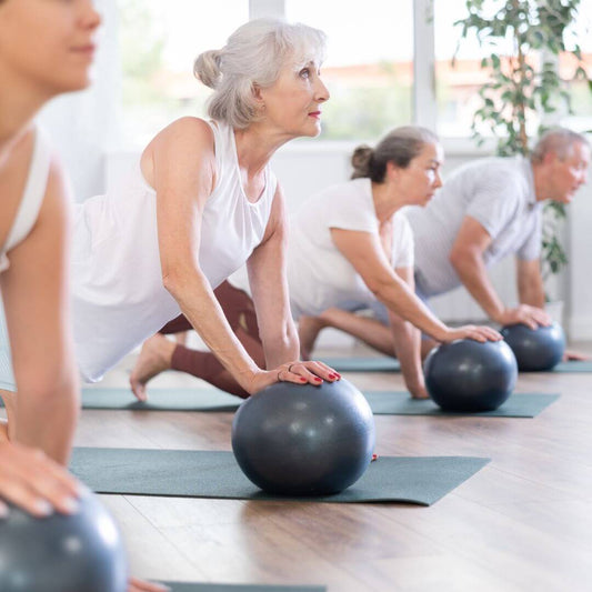 group of older people doing Pilates exercise 