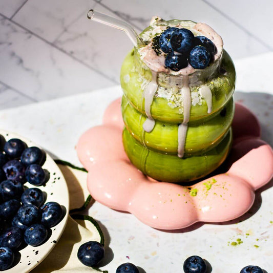 matcha collagen smoothie in a cloud glass with blueberries on the side