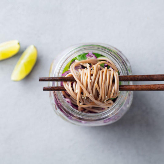 bone broth with noodles and vegetables and lemon